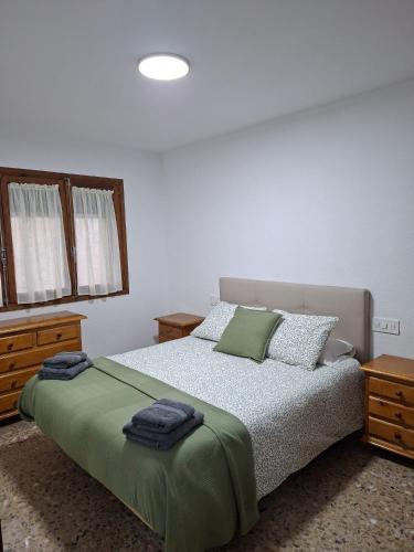 a bedroom with a bed with green sheets and pillows at El Rincon de Camarena in Camarena de la Sierra