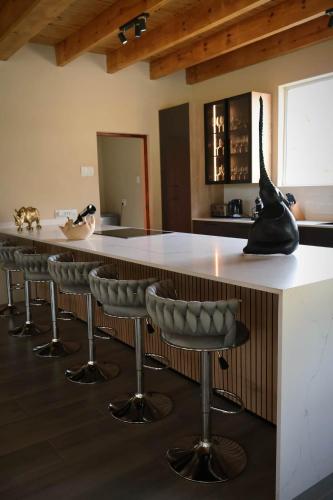 a kitchen with a large island with bar stools at Hemel Bushveld Lodge in Vaalwater