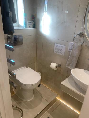 a bathroom with a toilet and a sink at Air Conditioned Modern Double Bed Room with Private Attached Bathroom - FREE Parking - Near London Heathrow Airport & Southall Broadway in Southall