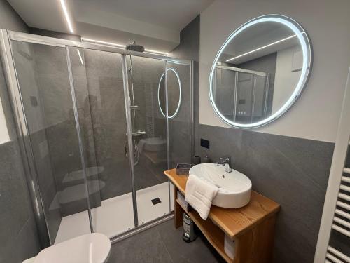 a bathroom with a shower and a sink and a mirror at Al Piz - Dimora Alpina in Pellizzano