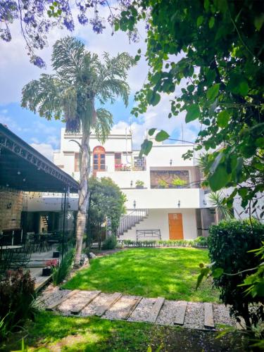 a courtyard with a palm tree and a building at Quinta María Hotel Boutique & Spa in Querétaro