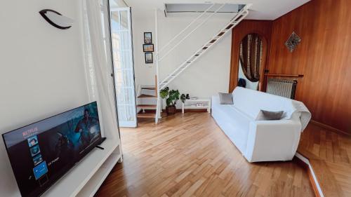 ein Wohnzimmer mit einem weißen Sofa und einem Fernseher in der Unterkunft Ca' hygge in Lavagna