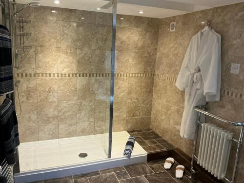 a shower with a glass door in a bathroom at Rorrington Hall in Chirbury