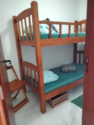 a room with two bunk beds and a chair at Casa Cordelia Mangaratiba Centro in Mangaratiba