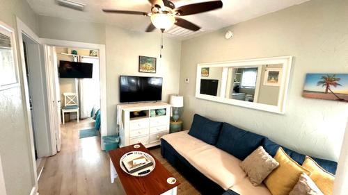 a living room with a couch and a flat screen tv at Sunny PaG Island rental wbikes-just steps2beach in St. Pete Beach