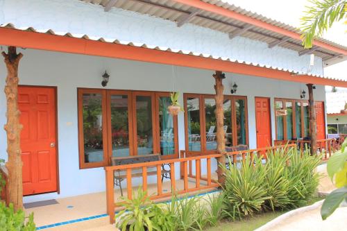 a building with a red door and some plants at Phuket Muay Thai House in Chalong 