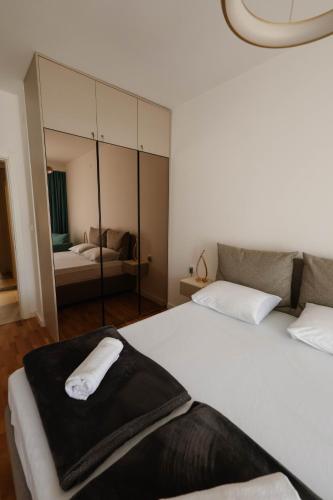 a bedroom with a large white bed and a mirror at Adria Gold - Bayview - Luxury in Kotor