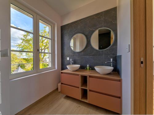 a bathroom with two sinks and two mirrors at La ROCHE D'ANJOU in Saint-Mathurin