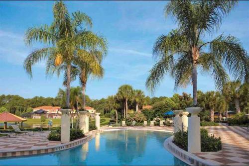 a swimming pool with palm trees in a resort at Near Disney Private Hot Tub April Deal in Kissimmee