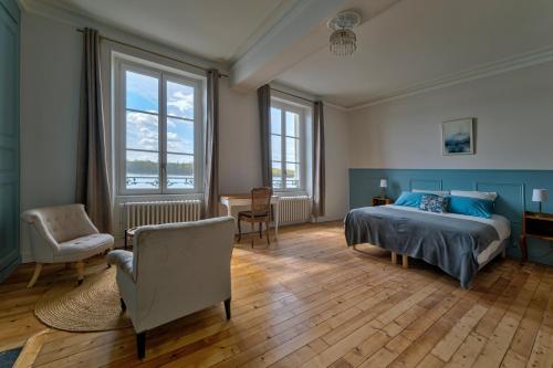 a bedroom with a bed and a desk and chairs at La ROCHE D'ANJOU in Saint-Mathurin