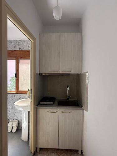 a kitchen with white cabinets and a sink at Merkaj House in Berat
