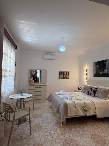 a bedroom with a large bed and a table at Merkaj House in Berat