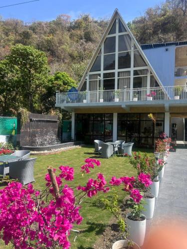 a building with a bunch of flowers in front of it at thesukoon in Bhīm Tāl