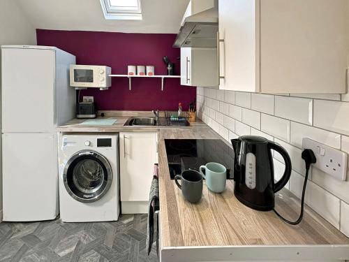 a kitchen with a washing machine and a sink at Cosy and convenient Sunderland apartment in Sunderland