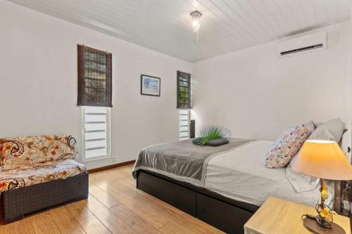 a bedroom with a bed and a couch and a lamp at Modern Villa with Pool & Garden in Farehau