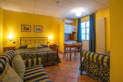 a bedroom with a bed and a table and chairs at Albergo Ristorante Badellino dal 1917 in Bra