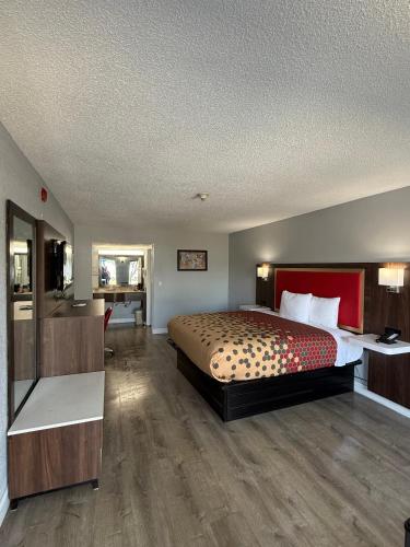 a hotel room with a bed and a bathroom at Econo Lodge Ruther Glen in Ruther Glen