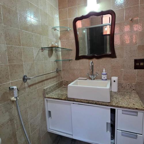 a bathroom with a sink and a mirror at Recanto do Capitão in Rio de Janeiro