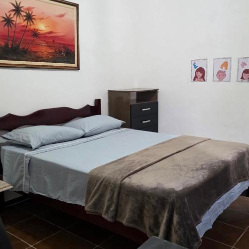 a bedroom with a bed and a picture on the wall at Recanto do Capitão in Rio de Janeiro