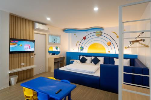a bedroom with a blue bed and a tv at KYP Hotel โรงแรมขุนยูวเพลส in Fang
