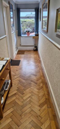 a hallway with a hard wood floor and a window at Greenlands Guest House in Highbridge