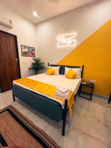 a bedroom with a bed with a yellow wall at Bingo Service Apartment Grand 3BHK in Alwar