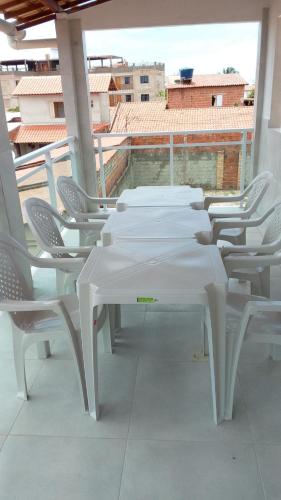 a row of white tables and chairs on a balcony at Casa Germania in Canoa Quebrada