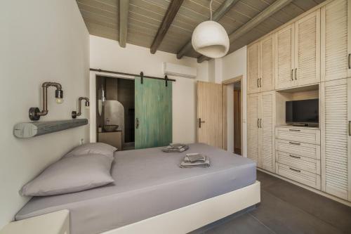 a bedroom with a large bed and a television at Rada Residence in Livadi