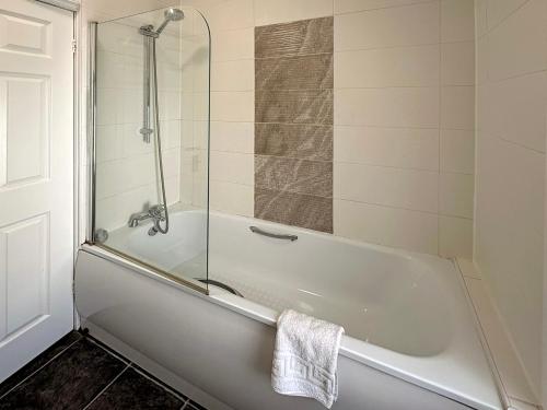a white bath tub with a glass shower door at Cosy and convenient Sunderland apartment in Sunderland