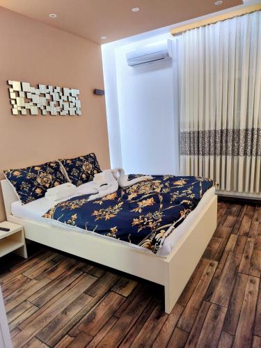 a bedroom with a bed and wooden floors at Robert's Apartment in Celje