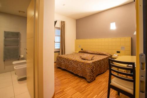 a bedroom with a bed and a bathroom at Albergo Ristorante Badellino dal 1917 in Bra
