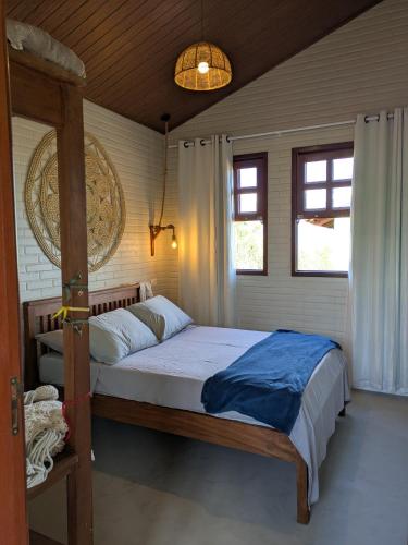 a bedroom with a bed with a wooden frame at Vila do Sussurro - Casinha Céu in Triunfo