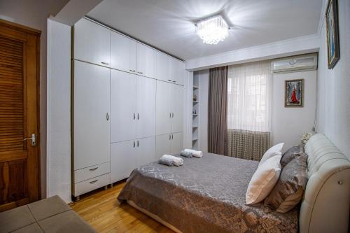 a bedroom with a bed and a large white cabinet at Cozy Apartment on Kostava in Tbilisi City