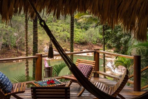 a porch with two chairs and a hammock on a deck at Blancaneaux Lodge by Francis Ford Coppola in San Ignacio