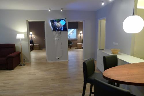 a living room with a table and a tv on the wall at Liiva Seaside Apartment in Haapsalu