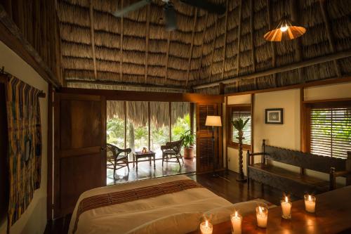a bedroom with a bed and a table with candles at Blancaneaux Lodge by Francis Ford Coppola in San Ignacio