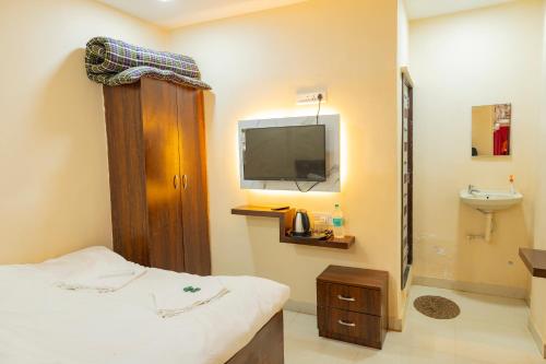 a room with a bed and a tv and a toilet at X Western Hills panchagani in Panchgani