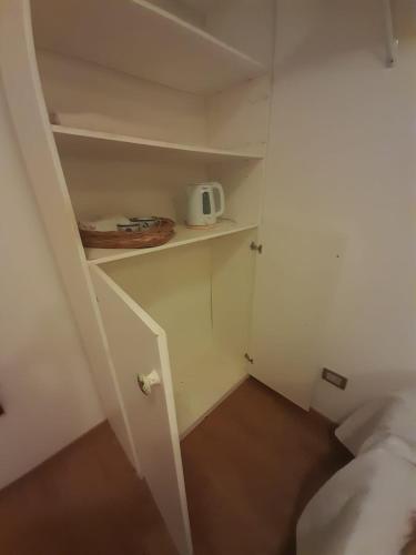 a small room with a bed and a white closet at Habitación en casa familiar "FILOMENA" in Puerto Madryn