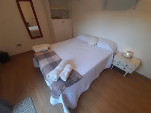 a bedroom with a white bed with towels on it at Habitación en casa familiar "FILOMENA" in Puerto Madryn