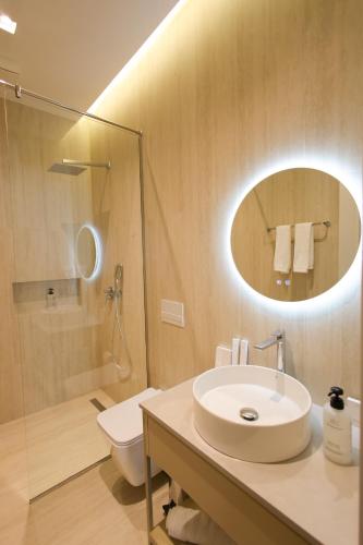 a bathroom with a sink and a toilet and a mirror at Dion Boutique Hotel - City Center in Krujë