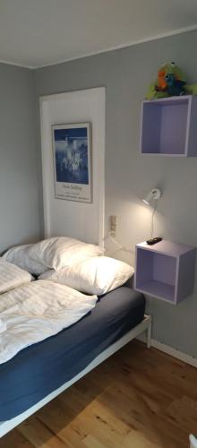 a bedroom with a bed and a nightstand with a lamp at Central Microflat, free parking, garden BBQ, LegoHouse, Legoland, in Billund