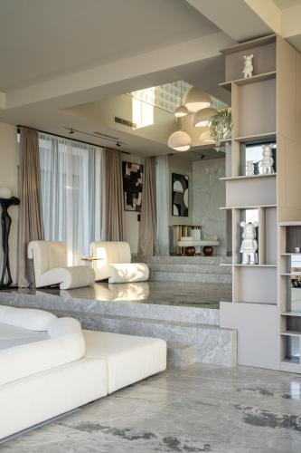 a living room with a white couch and chairs at Alicanto K1 in Polychrono