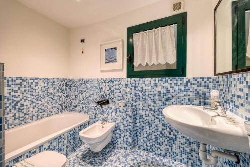 a blue and white bathroom with a sink and a tub at Stunning lake view, Cernobbio in Cernobbio