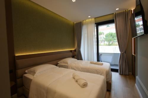 a hotel room with two beds and a window at Dion Boutique Hotel - City Center in Krujë