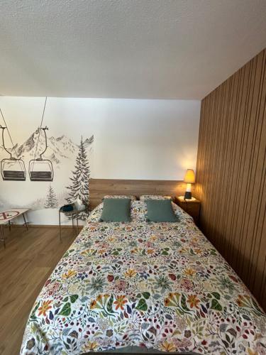 a bedroom with a large bed with a colorful blanket at Le Charme du Gaschney in Muhlbach-sur-Munster
