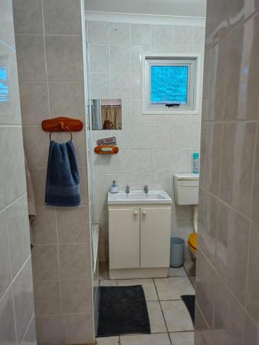 a bathroom with a sink and a toilet and a window at Lighthouse Studio in Doring Bay