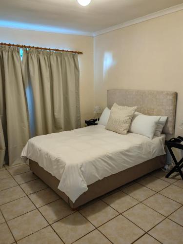 a bedroom with a bed with white sheets and pillows at Lighthouse Studio in Doring Bay