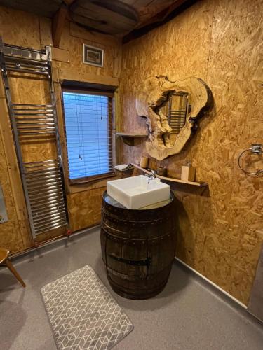 a bathroom with a sink in a barrel with a mirror at The Bothy Aberlour in Aberlour