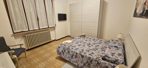 a bedroom with a bed and a chair and a window at Il Trebbiatore in San Costanzo