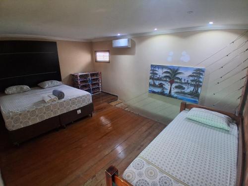 a room with two beds and a painting on the wall at Casa Recanto do sol in Natal